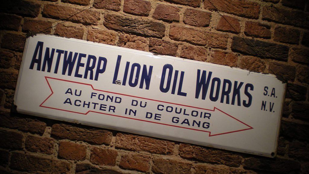 LIONOIL oude email bord van Antwerp Lion Oil Works tegen een bakstenen muur
